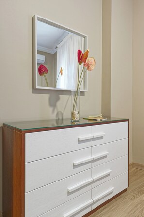 A white dresser with a glass top and a mirror above it. - Luxury APT - 2BR - South Teseen (I) (New Cairo City)