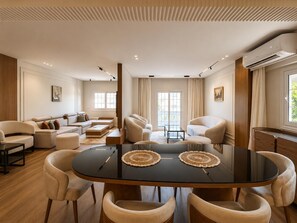 A modern living room with a round table, sofas, and a large window. - VESTA  - Luxury APT - 3BR - New Cairo (XXX) (New Cairo City)