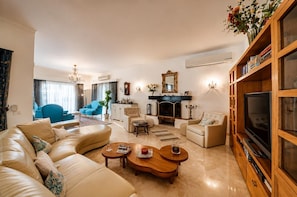 Ein Wohnzimmer mit Sofa, Couchtisch, Fernsehtisch und Kamin.
