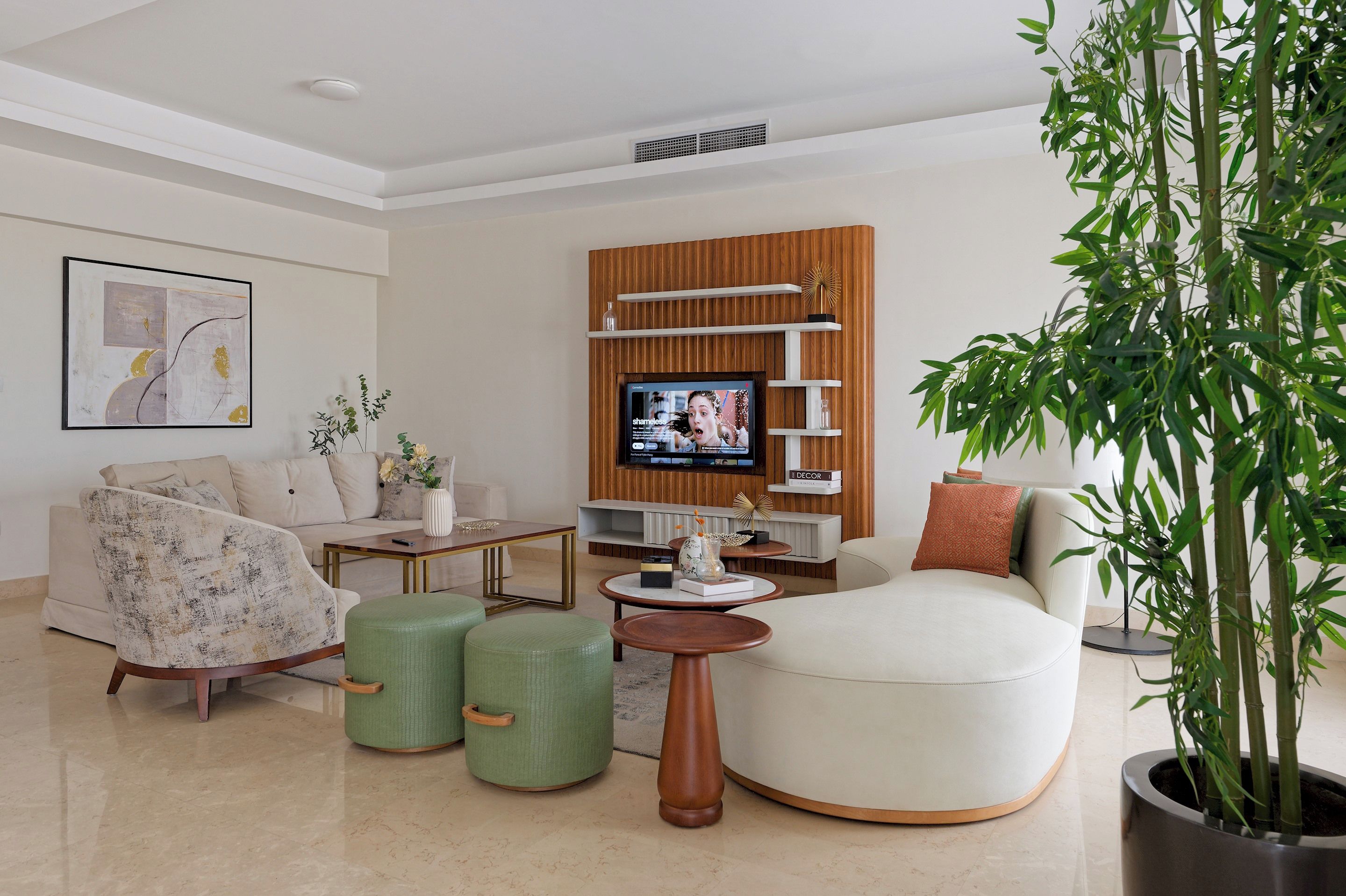 A modern living room with a sofa, armchair, coffee table, and a television.