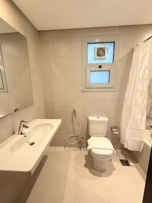 A bathroom with a white sink, toilet, and shower area. - VESTA - Luxury Apt- 3br - cfc (xlix) (New Cairo City)