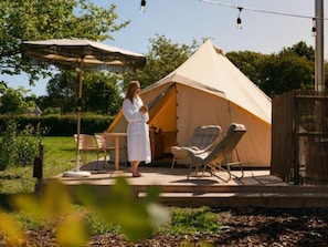 Een tent met een overdekte zithoek, een tafel en een stoel.
