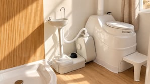 Un baño pequeño con lavamanos, inodoro y bidé blancos.