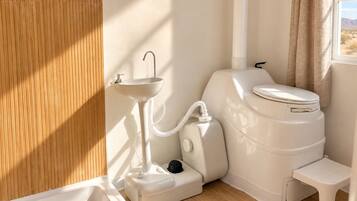 A compact bathroom with a white sink, toilet, and bidet.