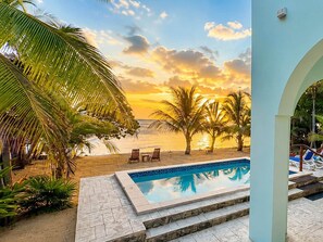 A pool area with a view of the beach and sunset. - Villa Terrapin Station in Hopkins, Beachfront, Private Pool + Rooftop Tiki Bar (Hopkins)