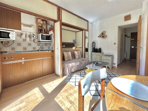 A compact kitchen with wooden cabinets, a microwave, and a sink. - Studio with slope view - 6 guests (La Salle-les-Alpes)