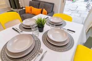 A dining table set with plates, glasses, cutlery, and a potted plant. - Bright & Modern Loft in the Heart of Turin (Turin)