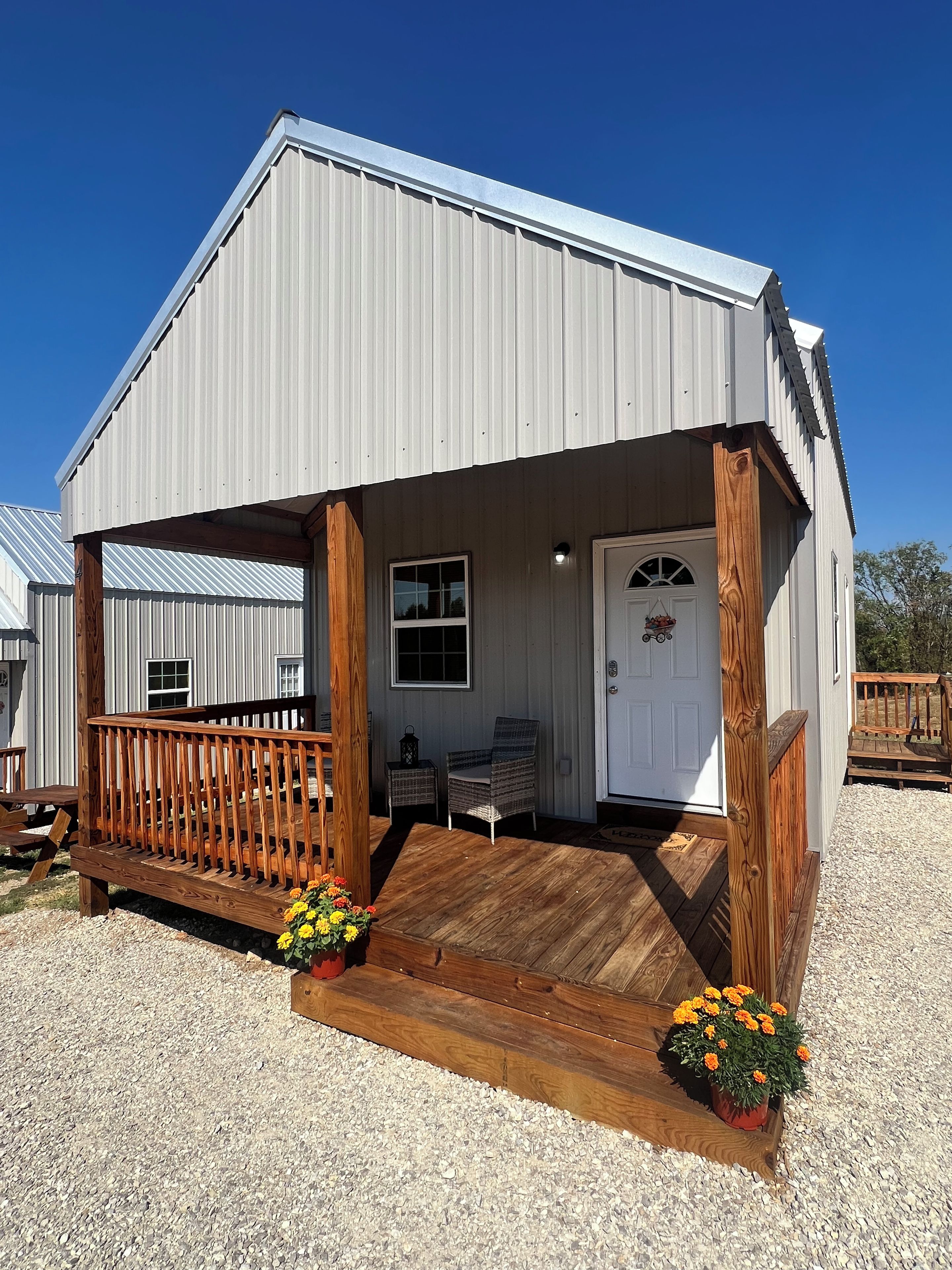 A single-story building with a porch, a door, and a window.