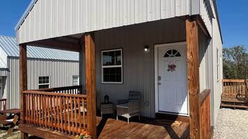 A single-story building with a porch, a door, and a window.