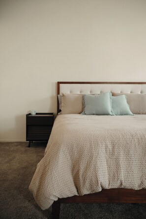 A bedroom with a bed, pillows, a nightstand, and a carpeted floor. - 4 Bedroom house with pool, putting green, and chef's kitchen! (Glendale)