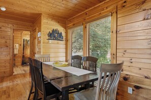 A wooden interior with a dining table, chairs, and a window with blinds. - Big Bear Estate. 1 mile to Dollywood! (Sevierville)