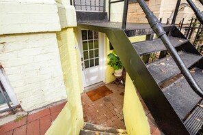 A staircase leading to a door with a potted plant beside it. - Cozy 2 BR Basement Suite (Washington)
