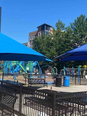 A playground with blue structures and benches, surrounded by a fence.