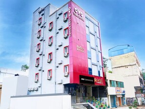 A multi-story building with a prominent red and white facade, featuring the signage 'OYO TOWNHOUSE' and 'Bansal's Arcade' on the ground floor. - Townhouse Casa Grand Himayatnagar (Hyderabad)