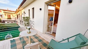 Ein Balkon mit Tisch, Stühlen und einer Topfpflanze.
