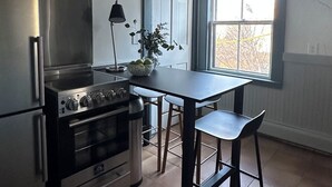 Eine Küche mit Herd, Kühlschrank und Fenster.