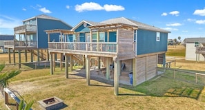 A two-story beachfront property with a covered deck and outdoor seating area. - Beach House 3Bed/2Bath with Ocean View & Golf Cart (Surfside Beach)