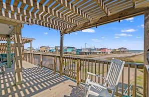 A wooden deck with a railing overlooking a beach and houses. - Beach House 3Bed/2Bath with Ocean View & Golf Cart (Surfside Beach)