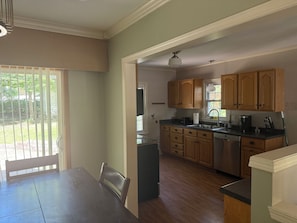 Una cocina con armarios de madera, una encimera y una zona de comedor con una mesa y sillas.