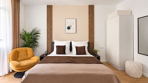 Een moderne slaapkamer met een bed, een stoel, een plant en een kledingkast.