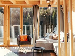 A modern interior with a sofa, armchair, and a small table. - Cabin in Niederwolz With Sauna (Oberwölz)