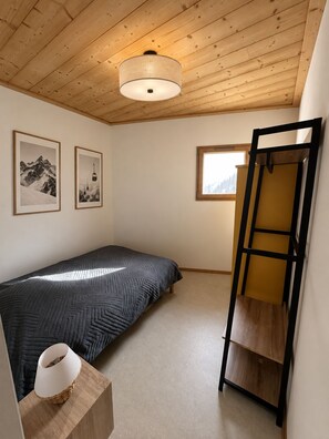 A small, cozy bedroom with a single bed, a wooden ladder, a window with a view, and two framed pictures on the wall. - New Condo / Sleeps 4 / Right on the slopes - Les Menuires (Les Belleville)