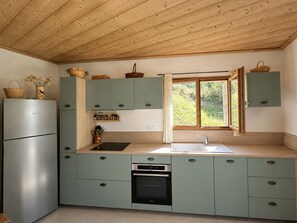 A compact kitchen with a Bosch refrigerator, a built-in oven, and a window with a view of greenery. - New Condo / Sleeps 4 / Right on the slopes - Les Menuires (Les Belleville)