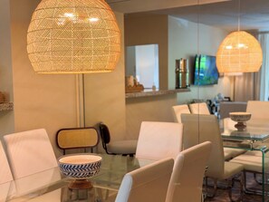 A modern dining area with a glass table, white chairs, and two large woven pendant lights. - Aventura Eden - 2-bedroom, Pool, Gym, Mall and Beach Oasis (Miami)