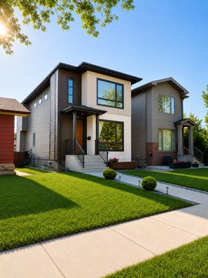 A modern two-story house with a front porch, a driveway, and well-maintained lawn. - Central Edmonton Home | Walk to 124St Restaurants | 5min downtown | Pet Friendly (Edmonton)