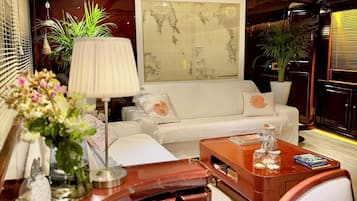 A modern living room with a white sofa, a wooden coffee table, and a large framed map on the wall.