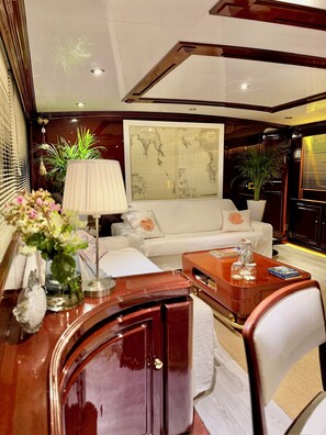 A modern living room with a white sofa, a wooden coffee table, and a large framed map on the wall.