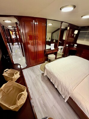 Un dormitorio con cama, tocador, espejo y armario.