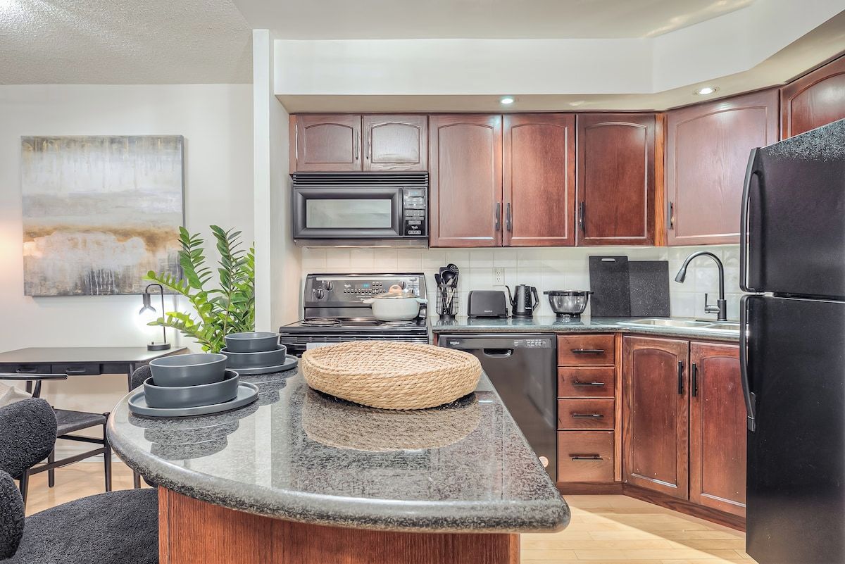 A modern kitchen with wooden cabinets, a microwave, a stove, and a refrigerator.