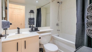 Une salle de bain avec des toilettes, un lavabo et une baignoire.