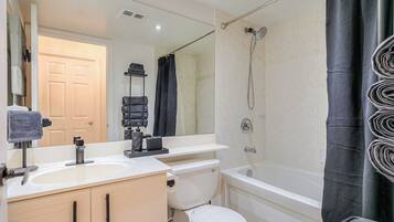 A bathroom with a toilet, sink, and bathtub.