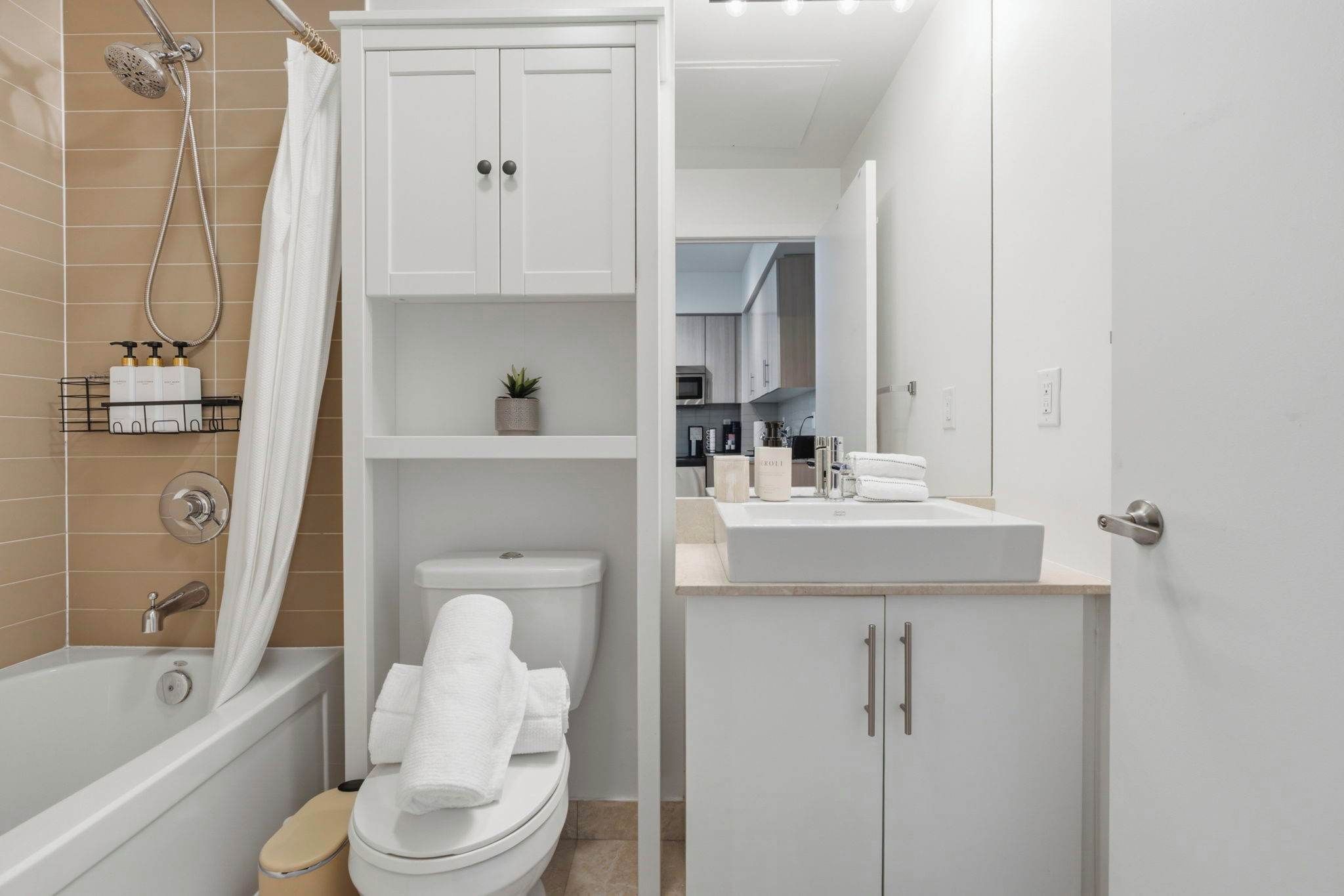 A modern bathroom with a bathtub, toilet, and a sink area.