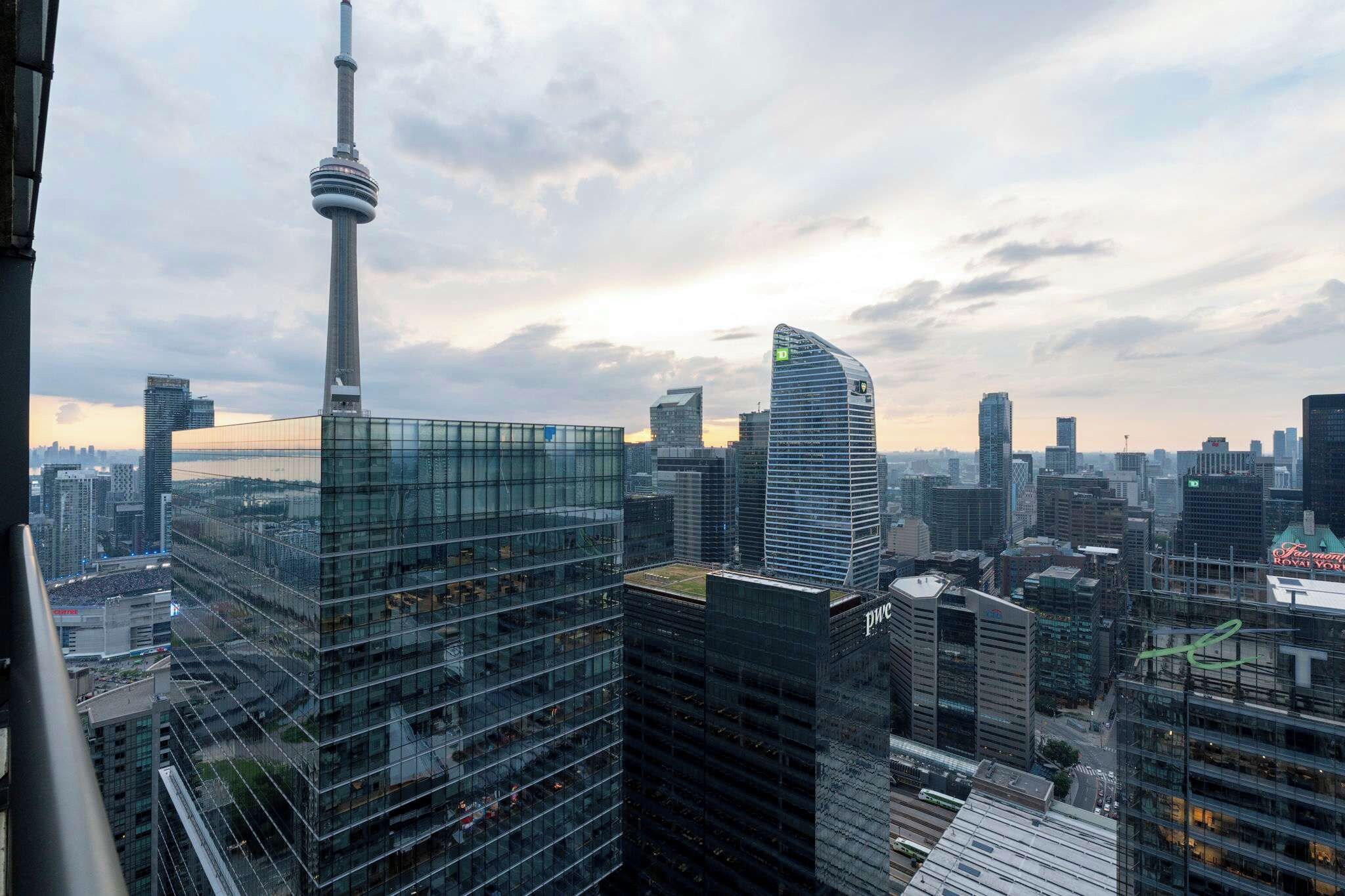 A cityscape with modern high-rise buildings, including a distinctive tower and a curved skyscraper.
