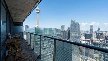 A balcony with a city view, including a tower and modern buildings.