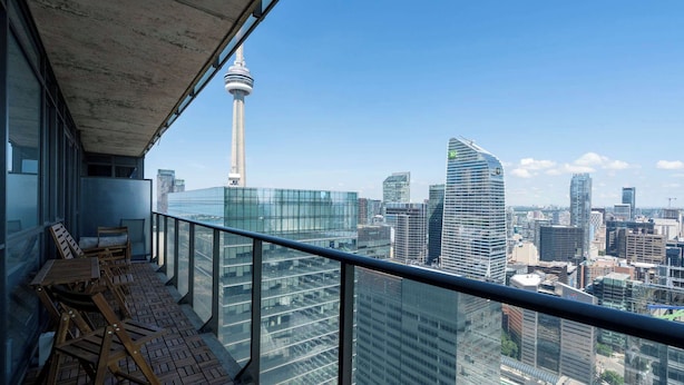 Varanda com vista para a cidade, incluindo uma torre e edifícios modernos.