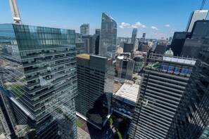 Un quartier urbain caractérisé par de nombreux immeubles de grande hauteur aux façades modernes en verre, dont un bâtiment particulièrement remarquable avec une façade incurvée et un logo bien visible.