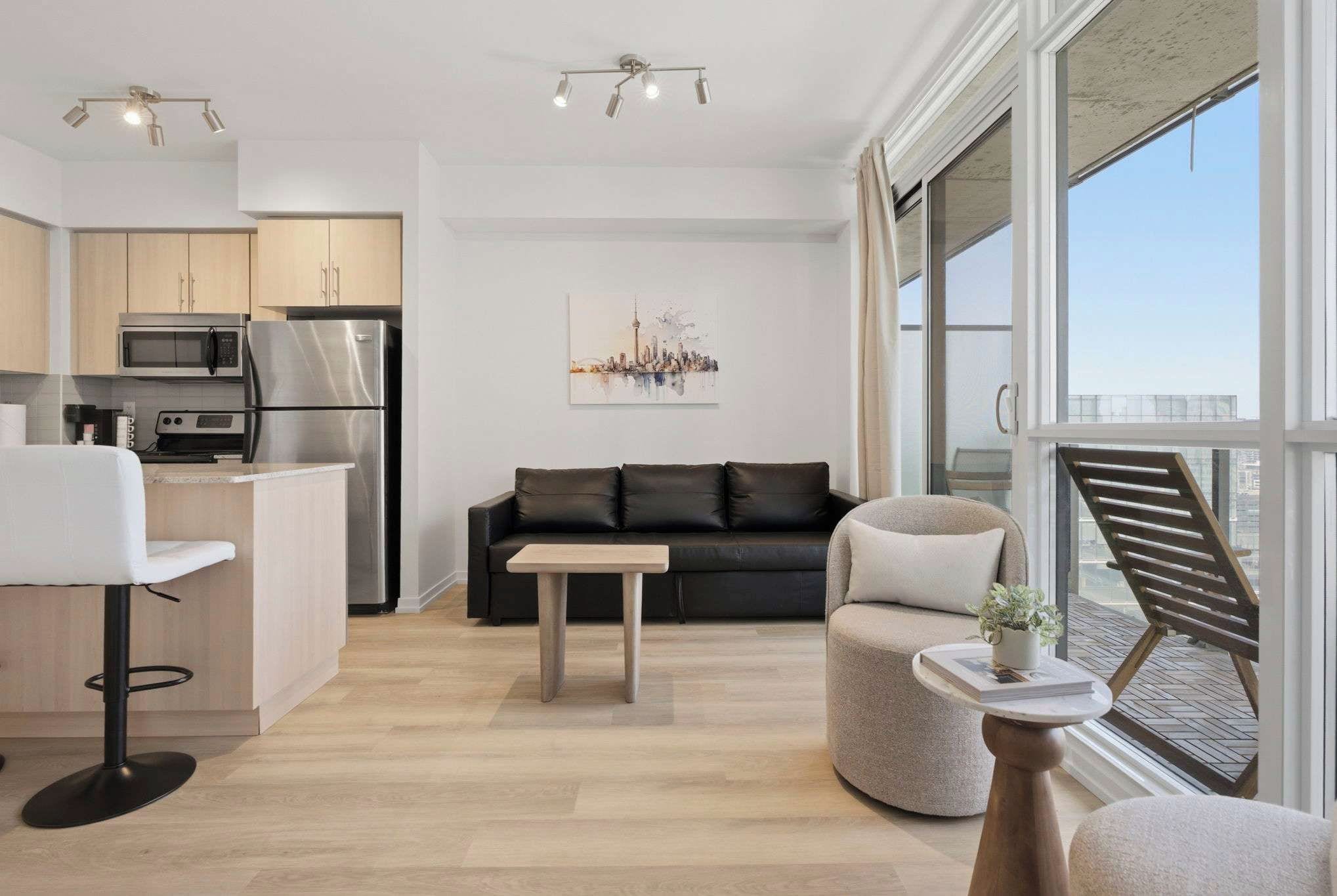 Bright, modern living space with cozy seating, Smart TV, and city views.