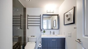 Un bagno moderno con WC, lavandino e zona doccia.