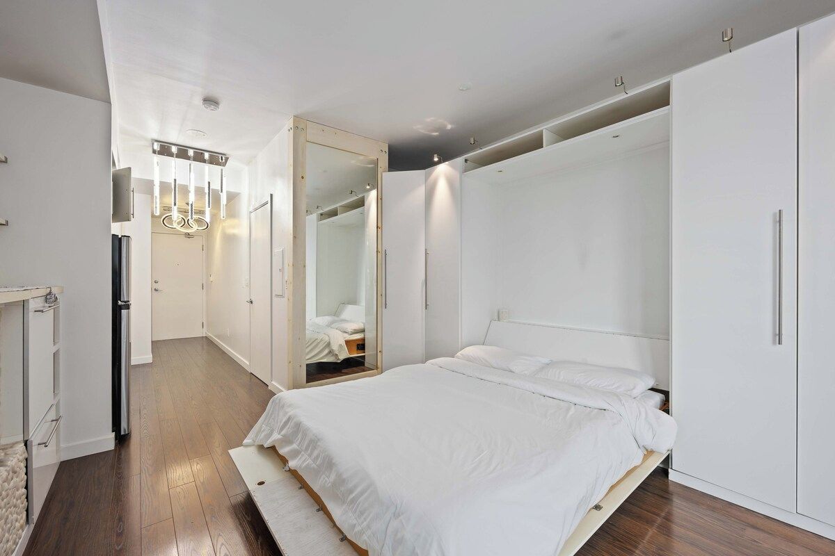 Un dormitorio moderno con una cama grande, armario empotrado y vestidor.