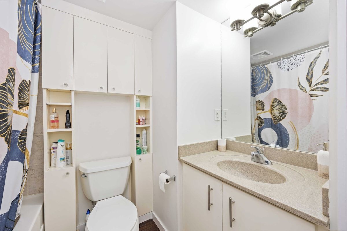 A bathroom with a toilet, a sink, and a mirror.