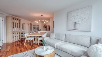 Uma sala de estar moderna com sofá, mesa de jantar e mesa de centro.