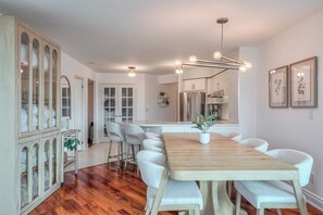 Una cucina moderna con un tavolo da pranzo in legno, sedie bianche e un forno a incasso.