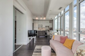A modern apartment with a living room, kitchen, and dining area. - CN Tower Views - 2BR Condo - Balcony - Fast Wi-Fi (Toronto)