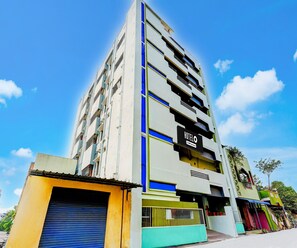 A multi-story hotel with a sign indicating it is serviced. - Classic With Balcony Rama Home Stay (Tirupati)