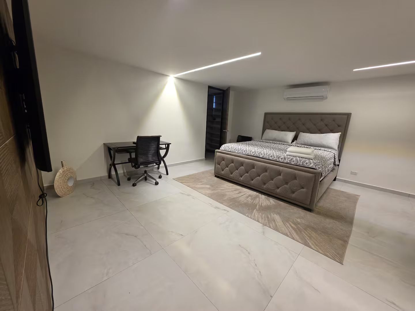 Un dormitorio con cama, escritorio y silla.