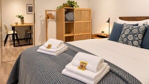 A hotel room with a bed, a desk, and a wardrobe. - book2stay: Apartment with Balcony near harbor & train station (Romanshorn)